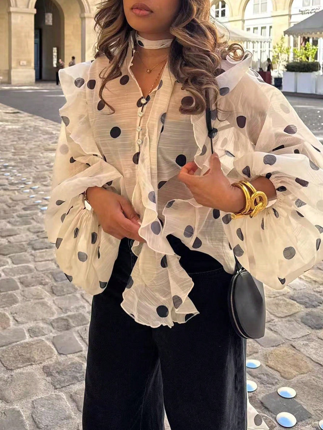 Une blouse semi-transparent en mousseline, couleur crème imprimée de grands pois noirs. Image principale du produit