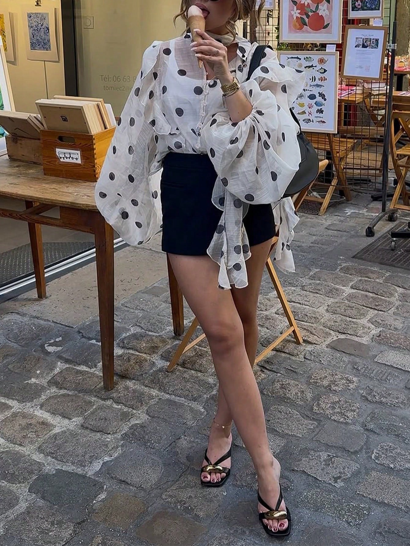 Une blouse semi-transparent en mousseline, couleur crème imprimée de grands pois noirs.